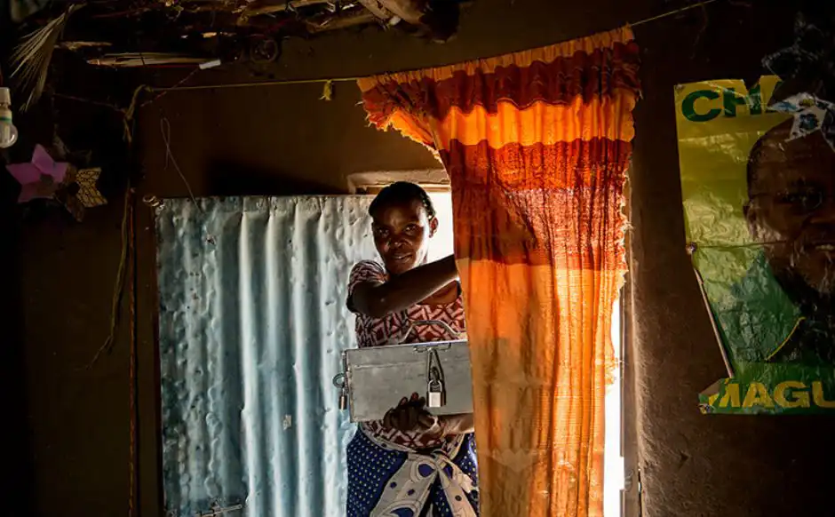 A woman enter a room with a box in her hand