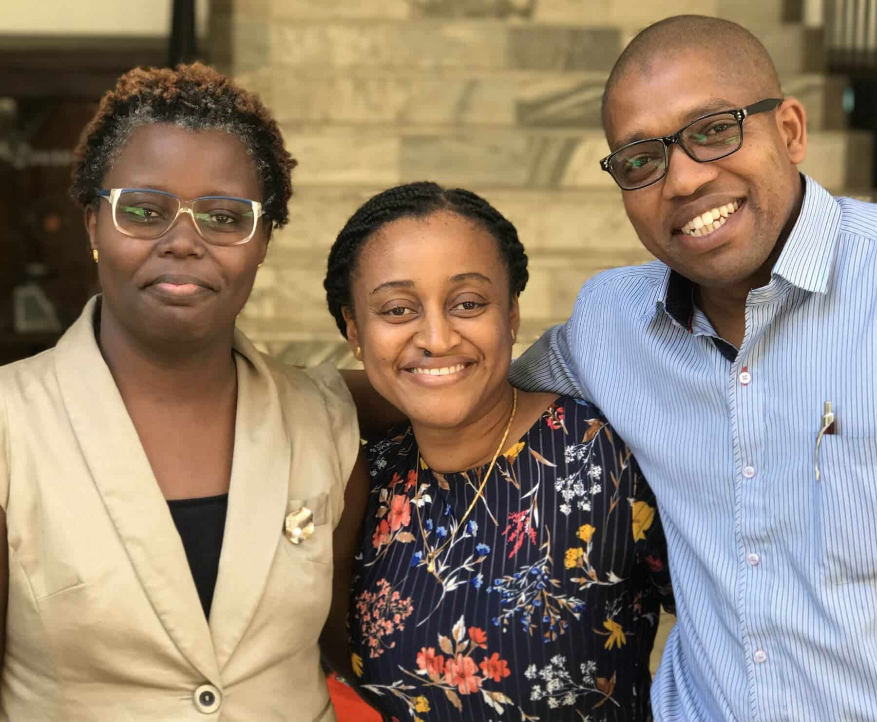 2 women and 1 man standing in MTI Investment office