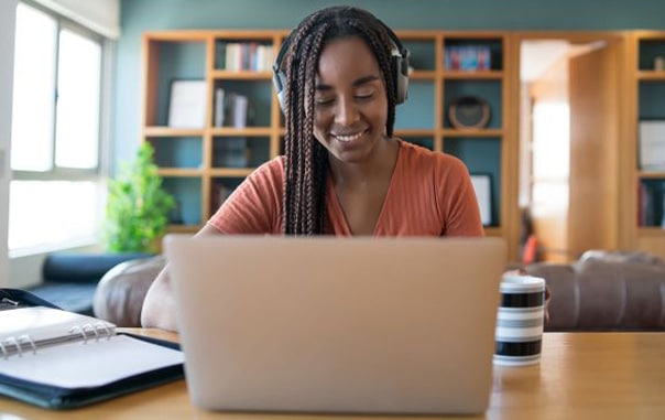 A women listenning some music while working on her laptop